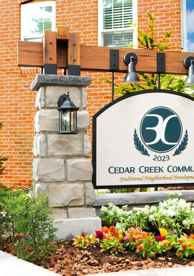 「CEDAR CREEK COMMUNITY」のサインと足元の花壇