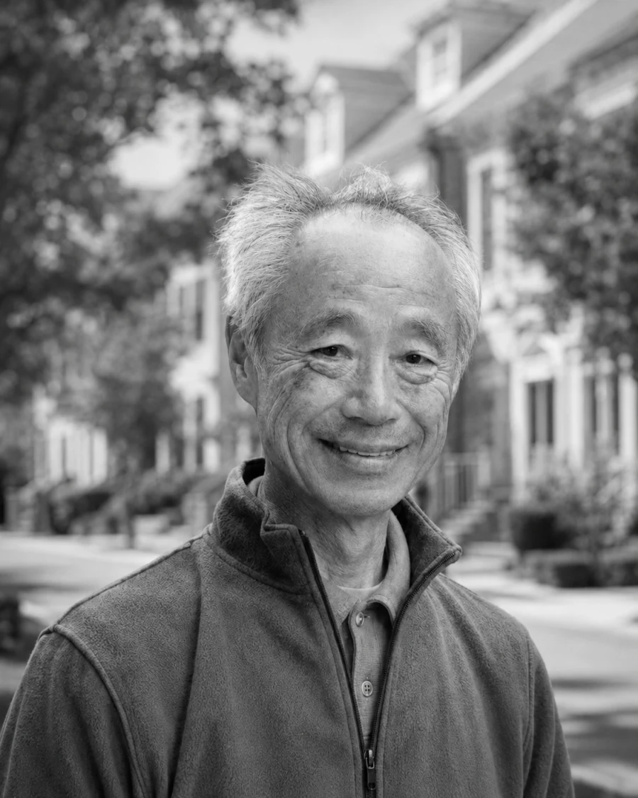 戸谷英世。米国の住宅地を背に立つ肖像